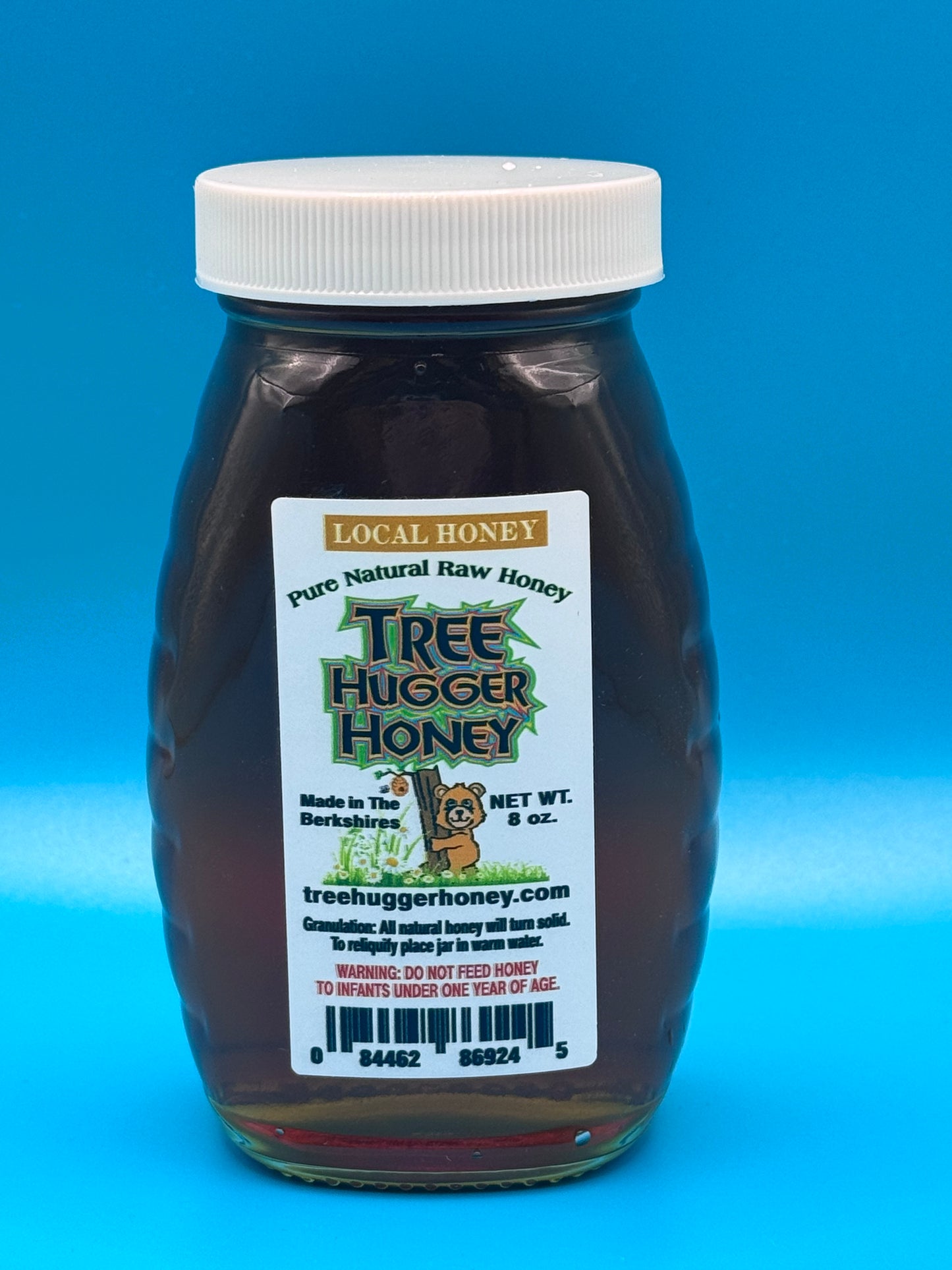 8 ounces of natural raw honey in a classic glass honey jar.